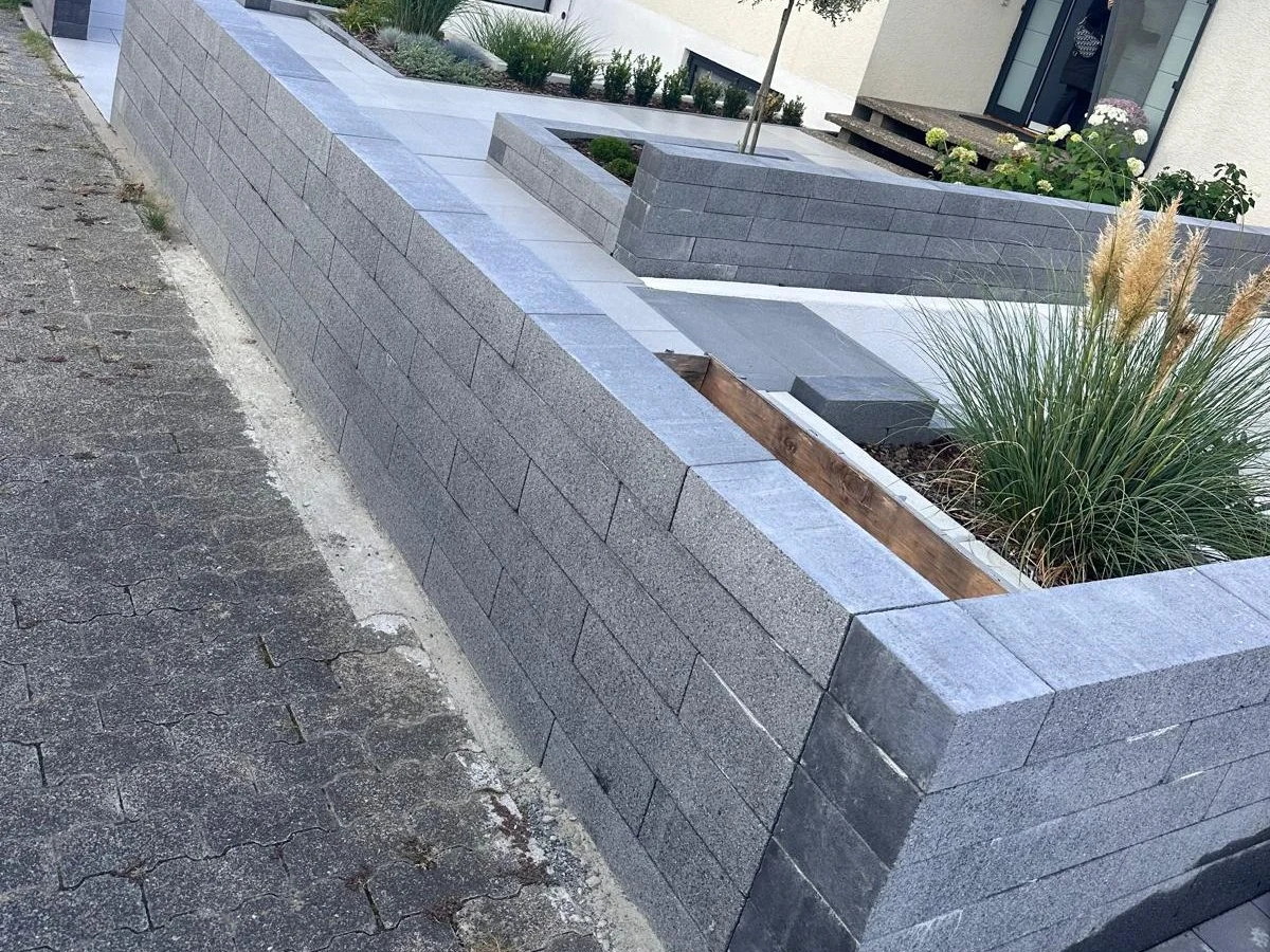 Moderne Gartenmauer mit integrierten Beeten